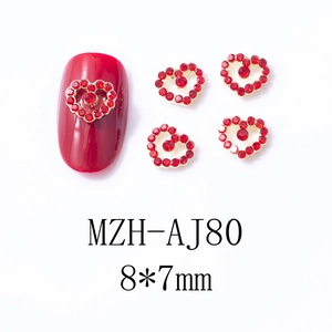 Vue macro de bijoux d'ongles en cœur rouge 8x7mm avec base dorée pour manucure