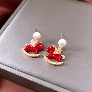 Gold plated rocking horse earrings with pearls and red enamel on satin background