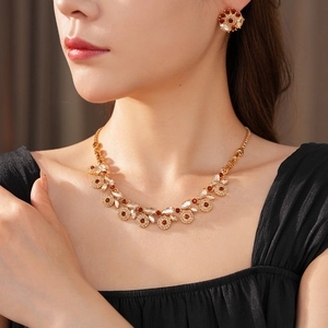 Close-up of vintage gold jewelry set with amber and white zircon stones on a model