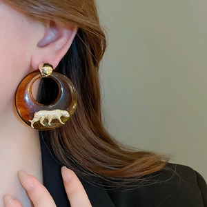 Macro view of vintage amber resin round earrings with gold leopard and crystal inlay