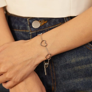 Minimalist silver stainless steel hollow heart chain bracelet worn on a female wrist
