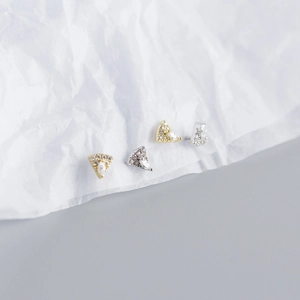 Macro shot of triangle pizza stud earrings in gold and silver with sparkling crystals