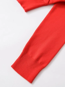 Close-up of red double-layer knitted jacket showing ribbed cuffs and fine stitching