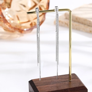 Macro detail of dangling rhinestone chain tassels on elegant silver drop earrings