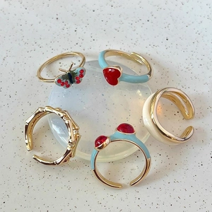Set of five gold adjustable enamel rings featuring butterfly, heart and frog designs