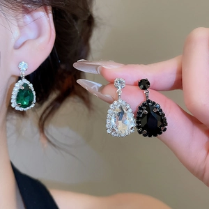 Detailed view of water drop earrings featuring green and white rhinestones in a luxury style