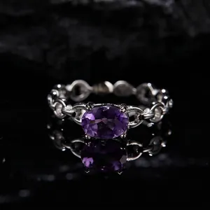 Macro shot of silver ring with oval purple amethyst and chain link band design