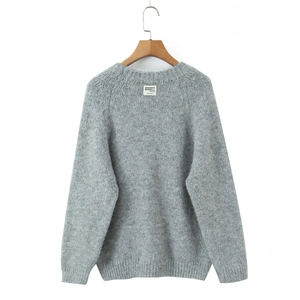 Detailed macro shot of grey crewneck knit sweater texture and brand neck label