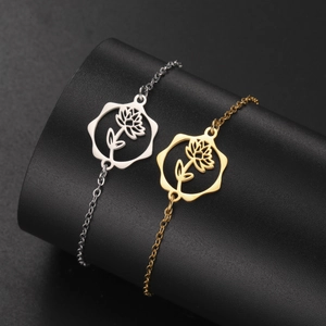 Detail of silver and gold stainless steel flower bracelets on a black display stand