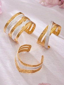 Detailansicht von drei gehämmerten Gold- und Silbermanschetten im zweifarbigen Design