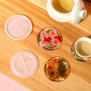 Detailed view of round silicone coaster molds and resin coasters with dried flower inserts