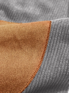 Detailed macro shot of grey corduroy and brown suede fabric texture on a polo sweatshirt
