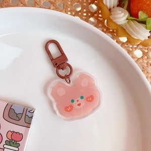 Close-up of a cute pink acrylic bear keychain with a dark brown metal lobster clasp
