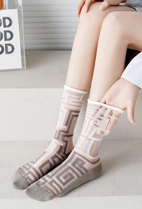 Detail of sheer mesh crew socks with gray geometric maze patterns on white fabric