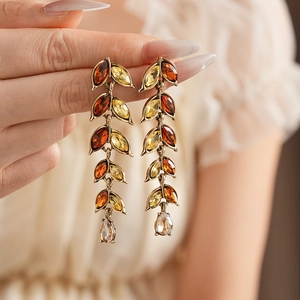 Détail de boucles d'oreilles vintage dorées avec cristaux ambrés et pampilles gouttes