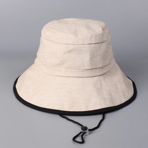 Detail of cotton linen sun hat with black contrast trim and adjustable drawstring