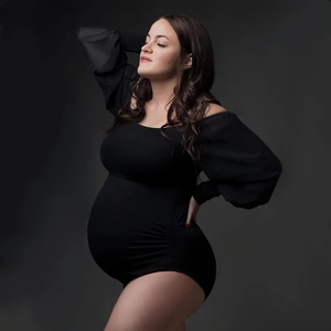 Detail of maternity bodysuit with off-shoulder long sleeves in stretch black fabric