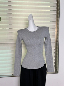 Détail d'un haut gris en modal à manches longues avec épaulettes et texture côtelée