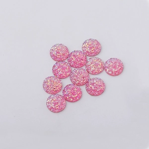 Close-up of 12mm pink druzy resin cabochons with sparkling glitter texture for DIY jewelry