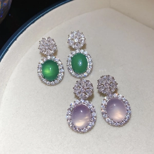 Vue macro de boucles d'oreilles en calcédoine avec clous fleurs brillants sur plateau