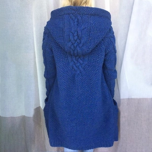 Dettaglio del cardigan blu reale in maglia grossa con cappuccio, trecce e ampie tasche