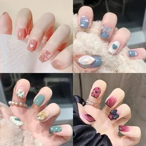 Detailed view of four handmade press-on nail styles with bows and glitter heart designs