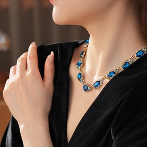 Collier vintage avec pierres bleues ovales et strass porté par un mannequin chic