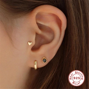 Detailed view of three 925 sterling silver earrings with heart and drop-shaped black gems