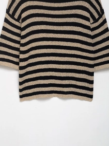 Détail de la maille texturée sur ce pull rayé noir et beige à manches tombantes