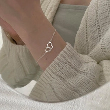 Detail of interlocking heart pendants on a thin S925 silver chain worn by model