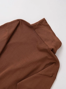 Close-up of the high-collar brown knitted sweater showing the fine stitching and soft texture