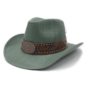 Detail of sage green straw cowboy hat with embossed leather band and silver studs
