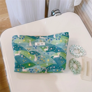 Detail of floral cotton makeup bag with rabbit prints and simple wish woven label