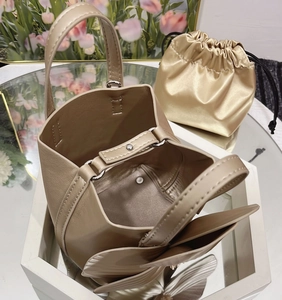 Detail view of champagne bucket bag with leather petals and satin drawstring liner