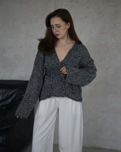 Dettaglio ravvicinato del cardigan in maglia grigio scuro con scollo a V da donna elegante