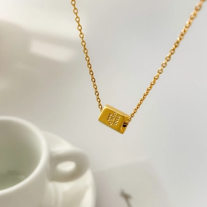 Detail of minimalist 18K gold plated titanium necklace with fine gold 999 engraving