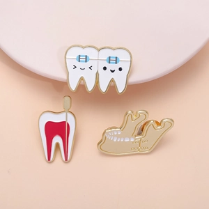 Cartoon tooth enamel pin set including braces and dental cross-section on pink background