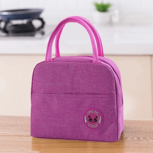 Detail of purple insulated lunch bag with panda logo on a wooden kitchen countertop