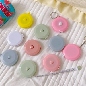 Detailed view of colorful 1.5m mini measuring tapes with dual scales on a white surface