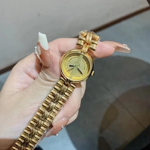 Detail of a vintage gold ladies watch with round dial and metal chain strap on wrist
