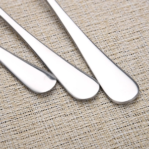 Close-up of three stainless steel spoons showing smooth handles and rounded ends on a placemat
