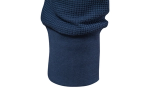 Macro view of navy blue waffle knit fabric and ribbed cuff details on a men's top