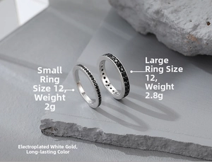 Macro shot of 925 sterling silver rings with black zircon inlay on a stone surface