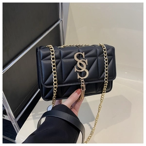 Detail of black quilted leather shoulder bag featuring gold GS logo and tassel accent