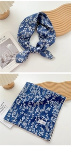 Detail of dark blue floral cotton linen scarf with white lace trim and fashion label