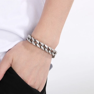 Detail eines klassischen silbernen Panzerarmbands mit Gravur am Handgelenk eines Mannes
