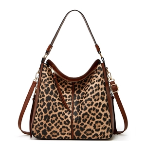 Close-up of leopard print tote bag with brown straps and golden hardware details