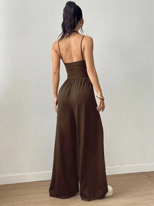 Detail of deep brown wide-leg jumpsuit showing the backless design with thin straps
