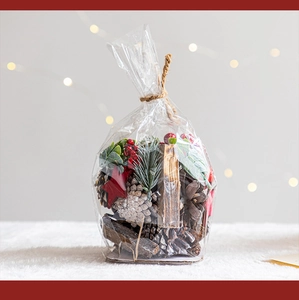 Détail d'un sac cadeau de Noël avec pommes de pin, baies rouges et ornements divers