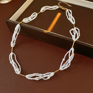Primer plano de collar de perlas vintage con cierre dorado sobre caja de cuero